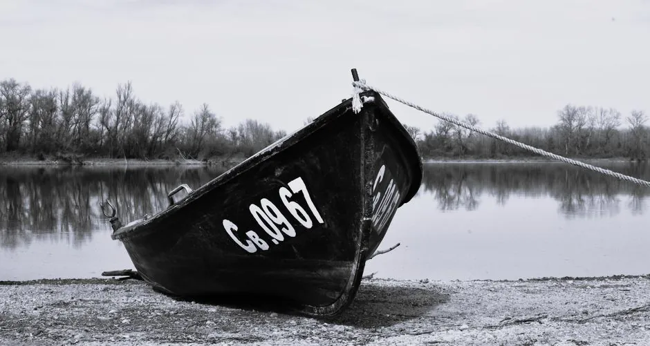 Moody black and white photo of a boat on the Danube riverbank in Bulgaria.