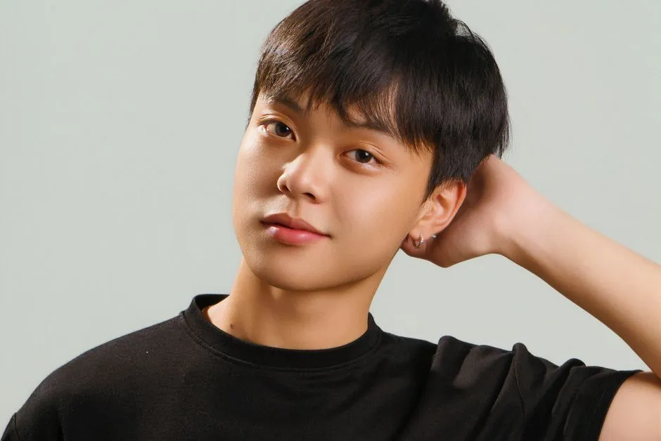 Studio portrait of a young Asian male model in a black t-shirt with a casual pose.