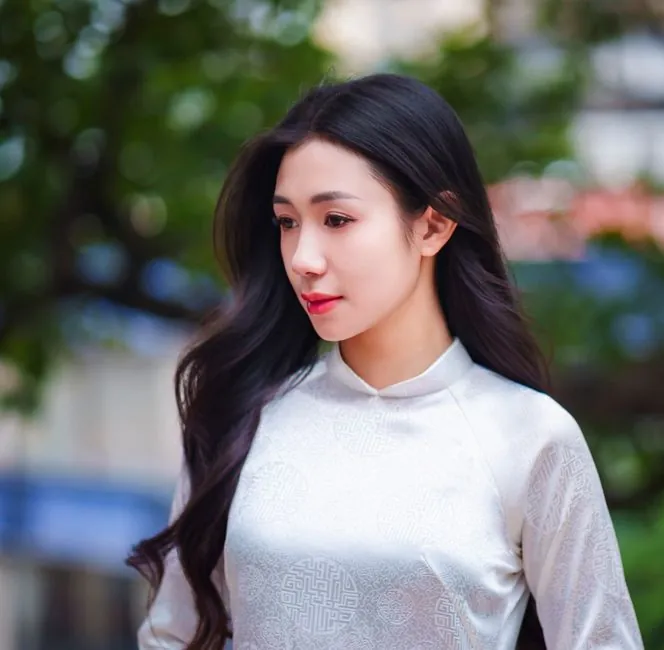 Beautiful woman wearing a white Áo Dài, captured outdoors in Ho Chi Minh City.