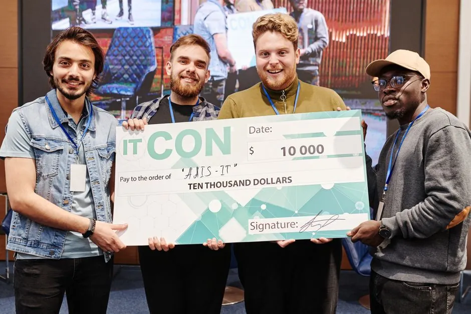 A diverse team of young professionals celebrates receiving a $10,000 cheque at IT conference.